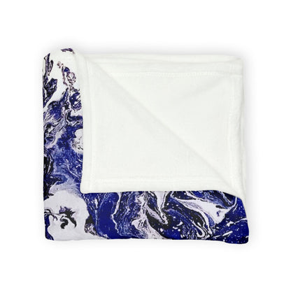 Folded colorful blanket featuring a vibrant pattern of floral and abstract shapes on a white background, reminiscent of a contemporary painting. Inspired by designs you only find in art studios, it brings a touch of artistic flair to your home decor and house decor. Perfect for enhancing any room with style and creativity, it is an ideal addition for those who appreciate thoughtful interior design and the beauty of art.