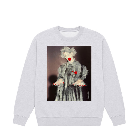 Front view grey sweatshirt featuring painting-style paintover graphic of a man or woman wearing a coat with red nails and red lips. This piece blends the world of art and fashion, standing out among trendy attires you only discover in artist studios.